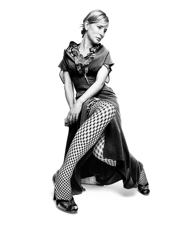 Black and white image of Cate Blanchett in dress with diamond-patterned tights on white background